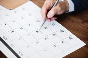 Mão anotando em um calendário